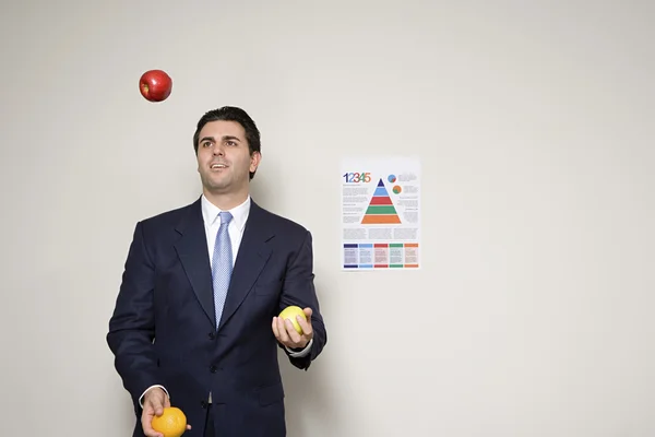 Empresario haciendo malabarismos con frutas — Foto de Stock