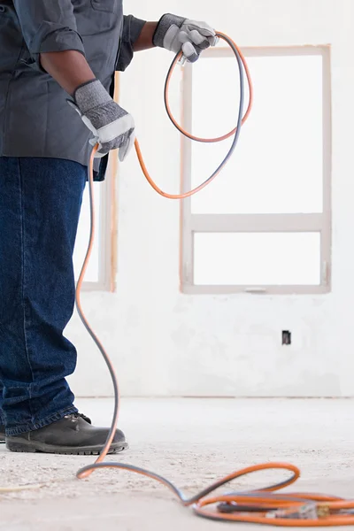 Een bouwer houden een kabel — Stockfoto