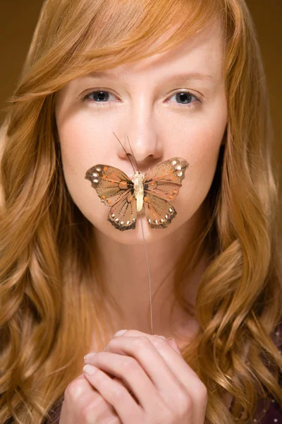 Butterfly covering womans mouth — Stock Photo, Image