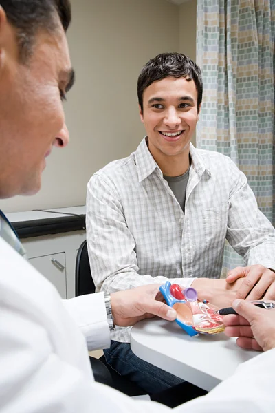 Läkare och patient med modell hjärta — Stockfoto