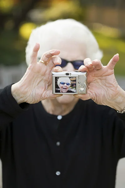 Senior woman taking a self portrait photograph — Stock Photo, Image