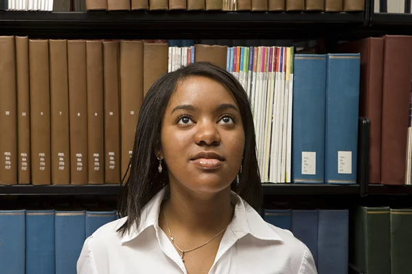 Vrouwelijke student kiezen een boek in de bibliotheek — Stockfoto