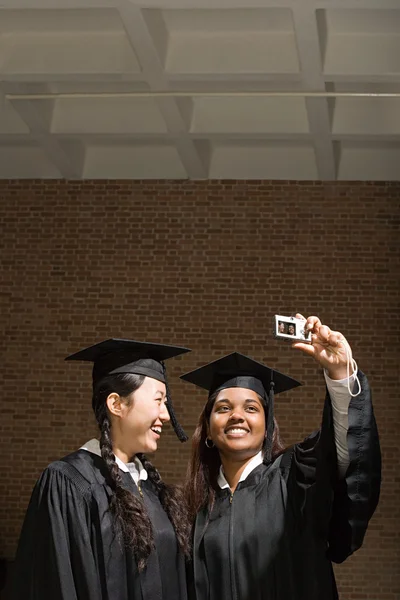 Dos mujeres graduadas tomando una fotografía —  Fotos de Stock