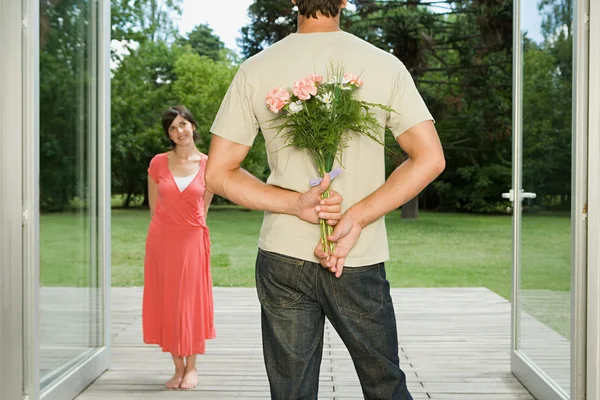 Hombre sorprendente esposa con flores — Foto de Stock