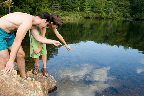 Menino e pai olhando para o lago — Fotografia de Stock