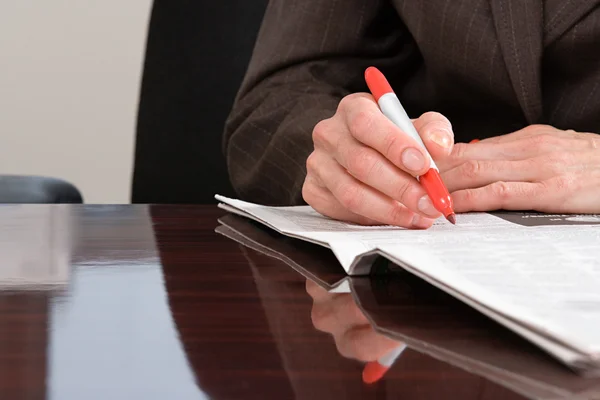 Person writing on newspaper — Stock Photo, Image