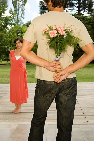 Man verrassende vrouw met bloemen — Stockfoto