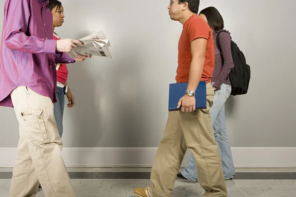 Vier studenten wandelen langs de corridor — Stockfoto