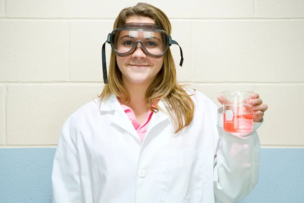 Female student holding flask of chemicals — Stock Photo, Image