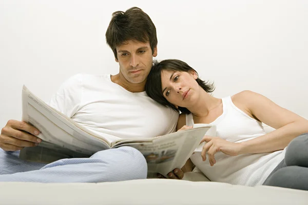 Jornal de leitura de casal na cama — Fotografia de Stock