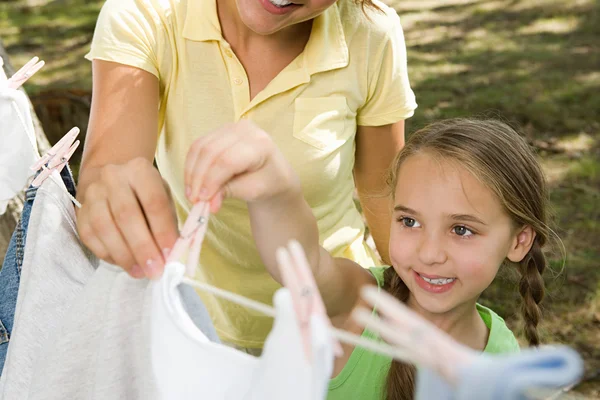 Mor och dotter hänga tvätt — Stockfoto