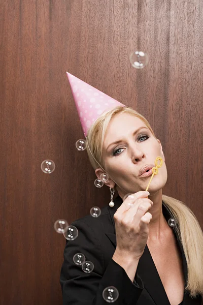 Businesswoman blowing bubbles — Stock Photo, Image
