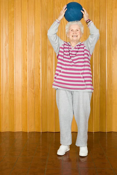 Äldre kvinna tränar med en boll — Stockfoto
