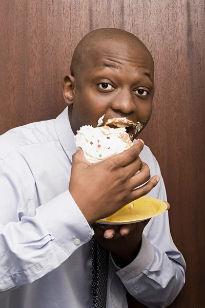 Businessman eating cake — Stock Photo, Image