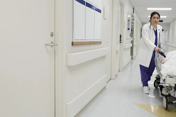 Médico levando paciente para baixo corredor — Fotografia de Stock