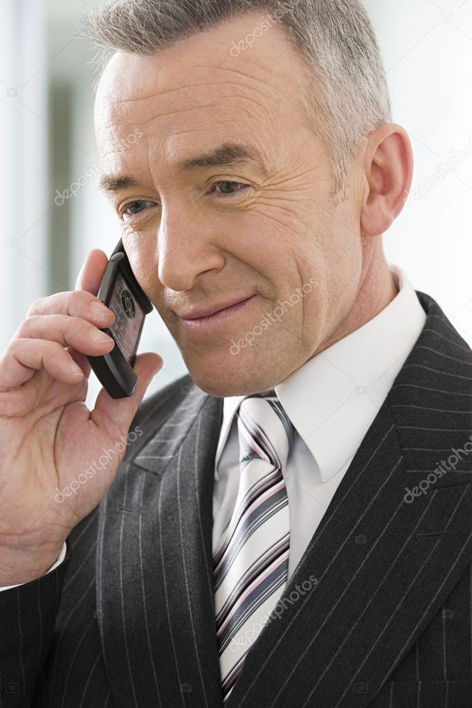 Mature businessman using a cellular telephone