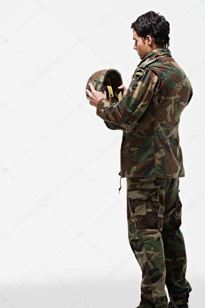 Male soldier putting on helmet