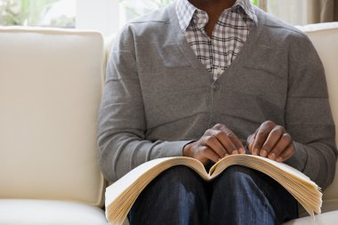 Kör adam kabartma kitap okuyor.
