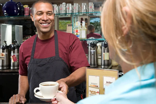 Waiter serving customer and smiling — Stock Photo, Image