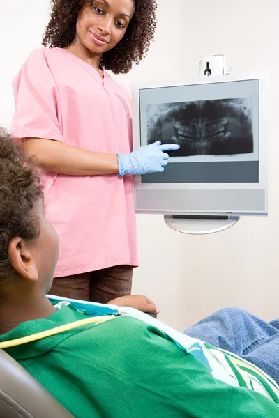 Enfermeira-dentista mostrando radiografia do paciente — Fotografia de Stock