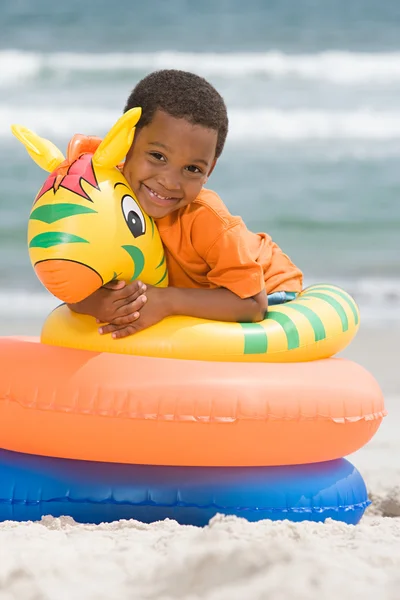 Boy hugging inflatable rings — Stock Photo, Image