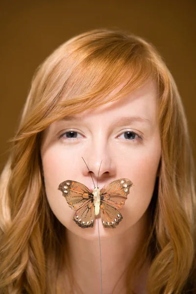 Butterfly covering womans mouth — Stock Photo, Image