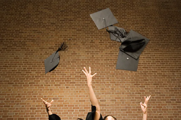 Les diplômés jetant leurs panneaux de mortier — Photo