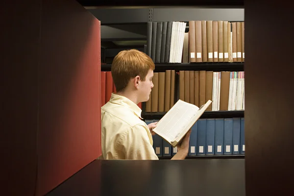 Férfi hallgató, olvasson a könyvtárban — Stock Fotó