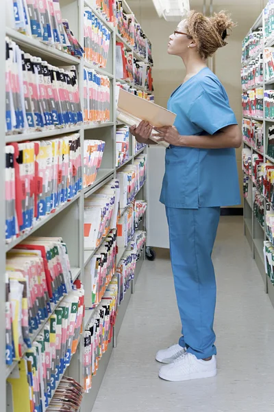 Hospital orderly in archives — Stock Photo, Image