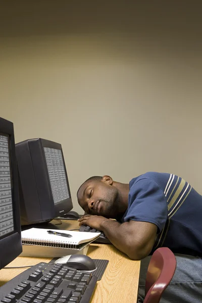 Estudante masculino dormindo em seu computador — Fotografia de Stock