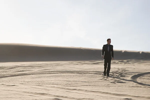 Uomo d'affari che cammina nel deserto caldo — Foto Stock