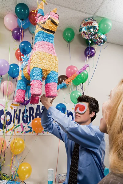 Office workers playing with a pinata — Stock Photo, Image