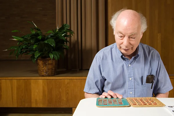 Homem sênior jogando bingo — Fotografia de Stock