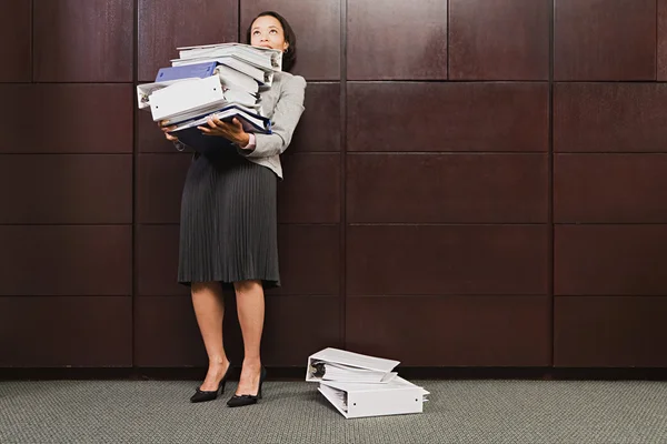 Mujer de negocios luchando con archivos pesados —  Fotos de Stock