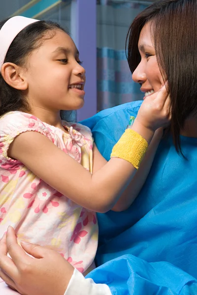 Enfermeira segurando menina feliz — Fotografia de Stock