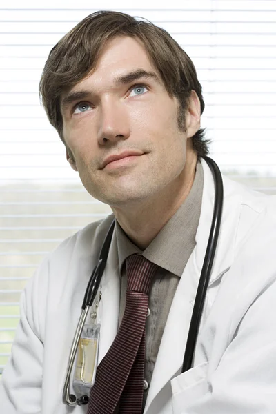 Doctor looking up and thinking — Stock Photo, Image