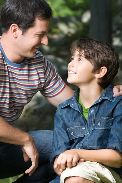 Vater und Sohn lächeln einander an — Stockfoto