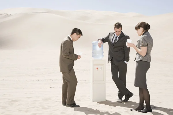 Pessoas ao redor do refrigerador de água no deserto — Fotografia de Stock