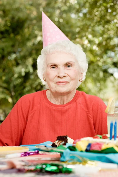 Senior vrouw op een verjaardagsfeestje — Stockfoto