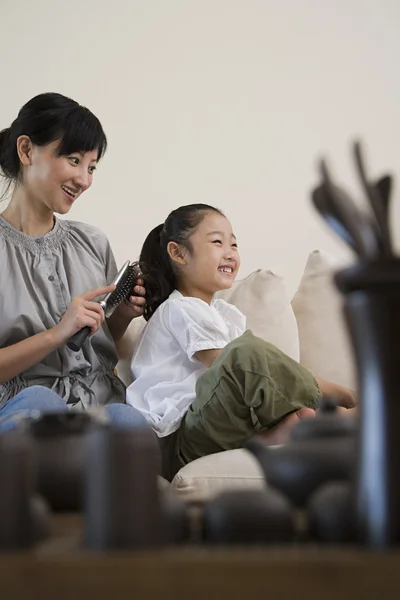 Eine Mutter bürstet ihren Töchtern die Haare — Stockfoto