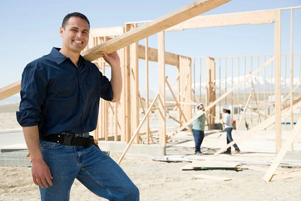 Portret van een bouwer met houten plank — Stockfoto