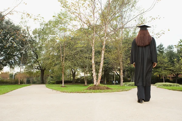 Жінка-випускниця йде стежкою — стокове фото