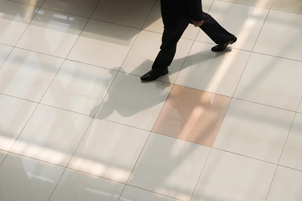 Бизнесмен ходит по кафельному полу — стоковое фото
