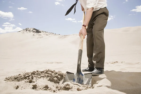 Man digging in desert — Stock Photo, Image