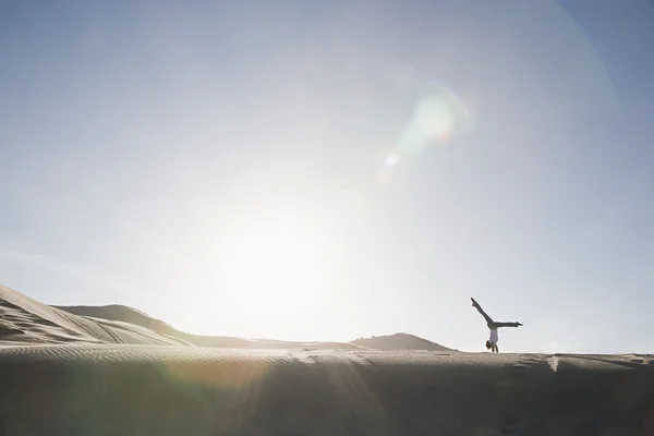 Femme faisant handstand dans le désert — Photo