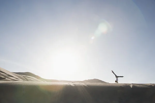 Mulher fazendo suporte de mão no deserto — Fotografia de Stock