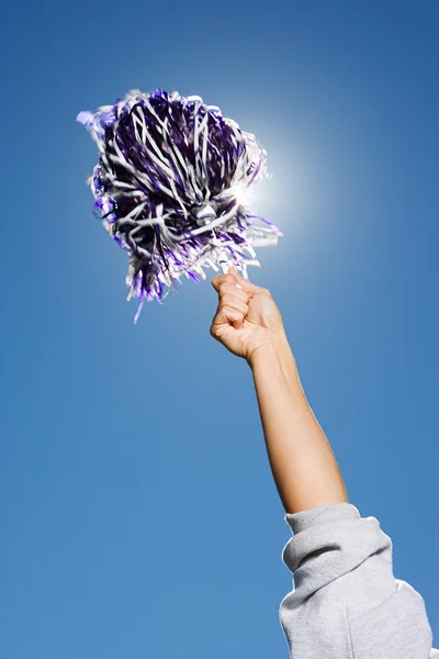 Braço de uma líder de torcida que mantém pom-pom — Fotografia de Stock