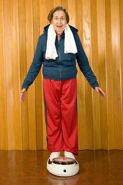 Senior woman stands on scales — Stock Photo, Image