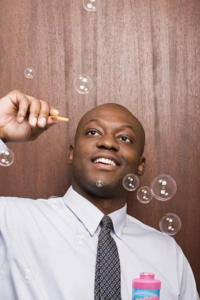 Uomo d'affari che gioca con le bolle — Foto Stock