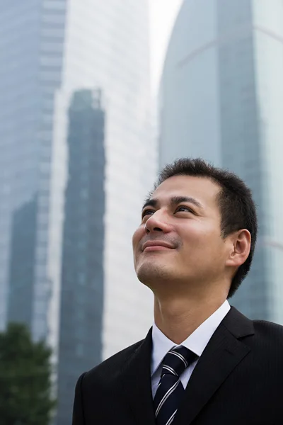 Grinning businessman looking up — Stock Photo, Image